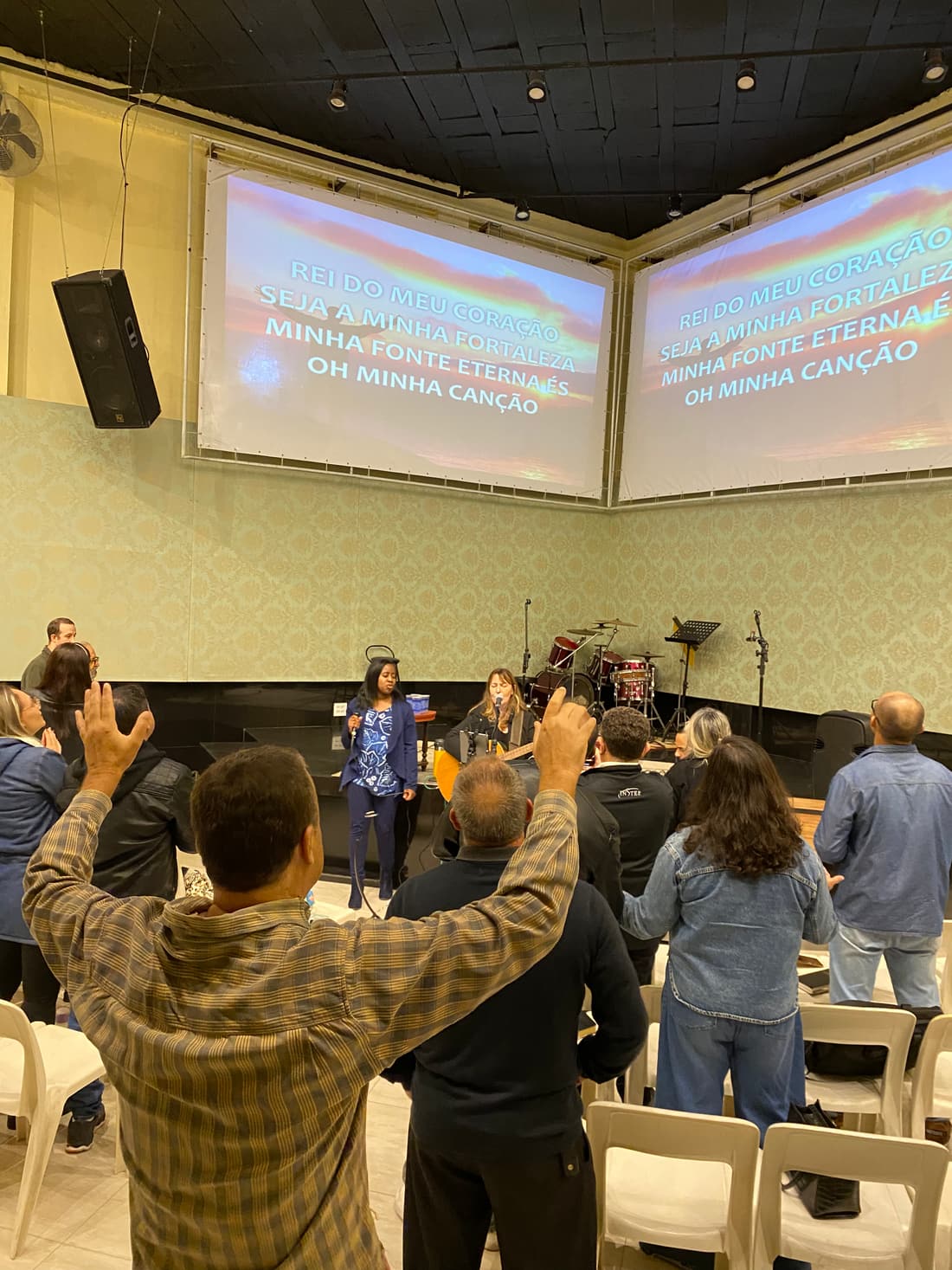 A congregation in Brazil lifting their hands in praise as the team leads