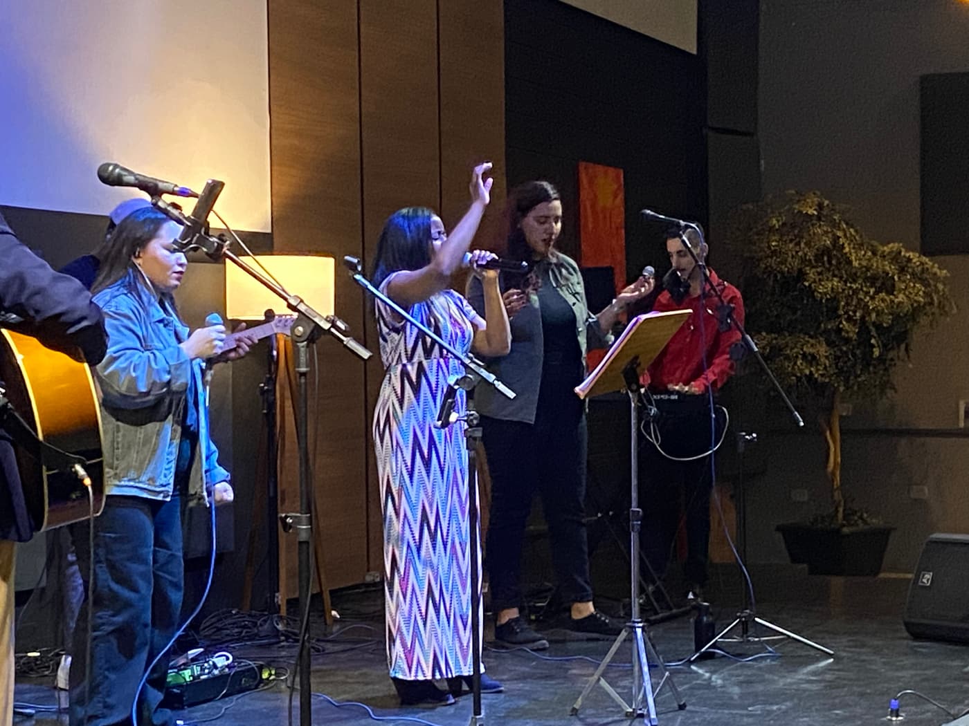 Singers and musicians leading worship on a stage