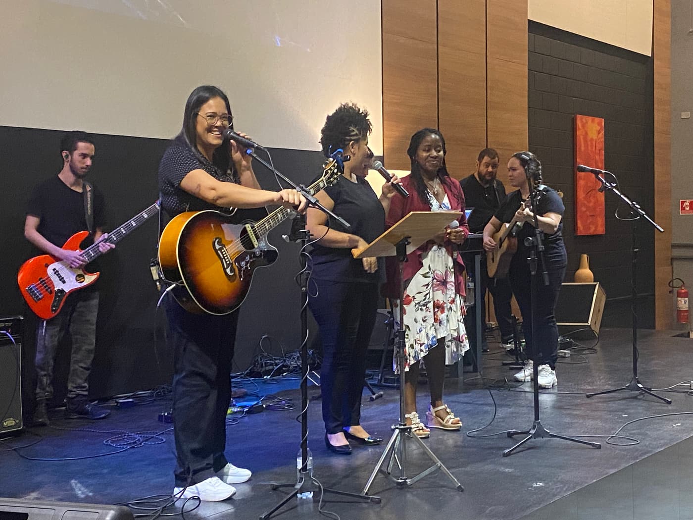 A worship band on stage with guitars, bass and singers
